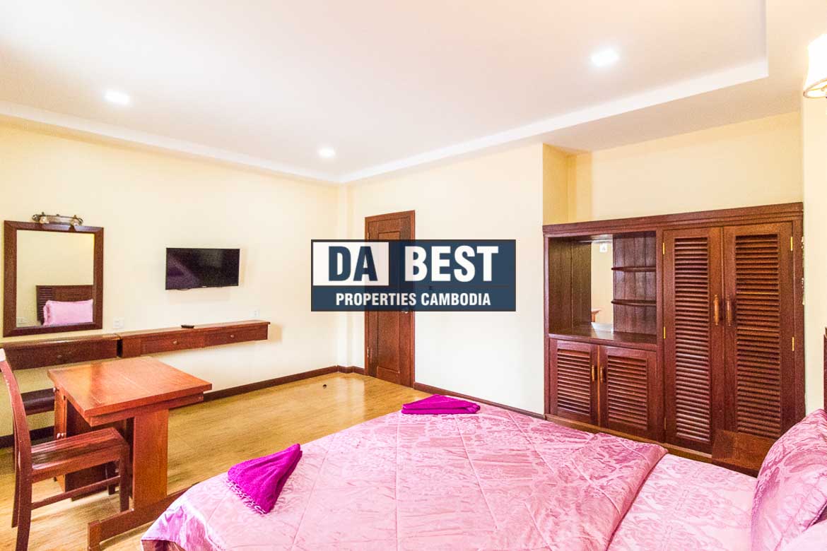 Generous 2 bedroom serviced apartment for rent in Siem Reap Angkor view of master bedroom with working desk, window and pink bedsheets and mirror