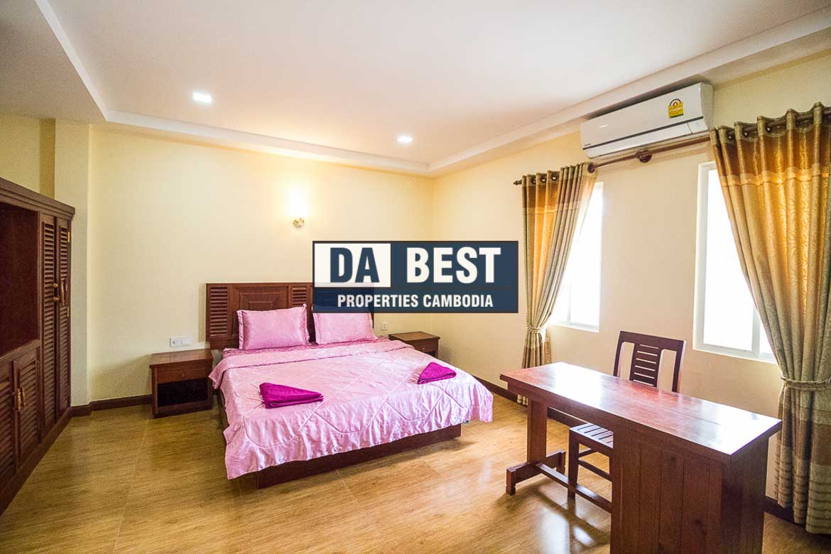 Generous 2 bedroom serviced apartment for rent in Siem Reap Angkor view of master bedroom with working desk, window and pink bedsheets
